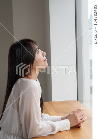 窓から外を見て考える女性 134582485