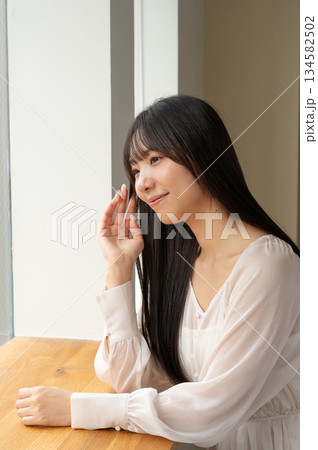 窓から外を見る女性 134582502