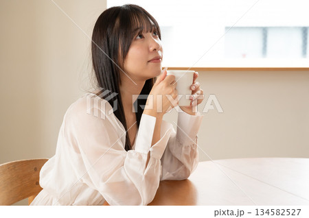 カフェでリラックスする若い女性 カフェでリラックスする若い女性 134582527