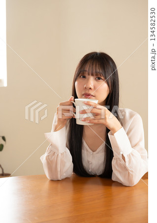 部屋でコーヒーを飲む女性 134582530