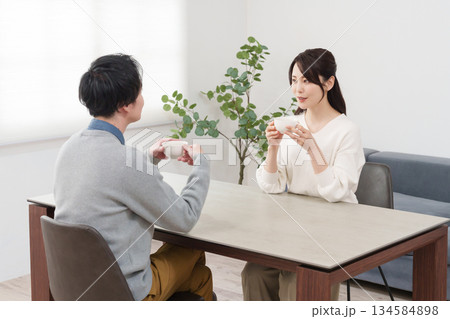 家で飲み物を飲みながら会話する夫婦 134584898