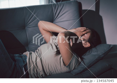 Sorrowful woman sat alone, overwhelmed by emotion, her sad and unhappy expression revealing deep despair, stress and distress left feeling depressed. sorrowful sad, despair alone, depressed stress 134587045