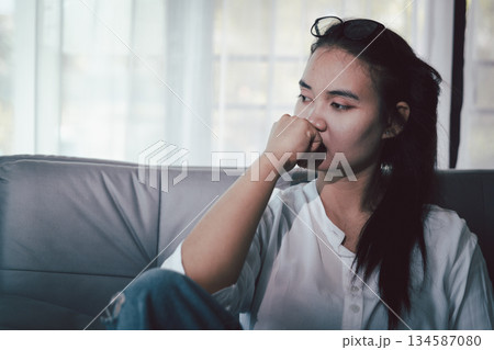 Sorrowful woman sat alone, overwhelmed by emotion, her sad and unhappy expression revealing deep despair, stress and distress left feeling depressed. sorrowful sad, despair alone, depressed stress 134587080