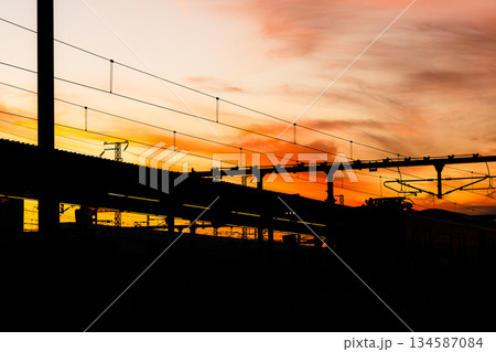 夕暮れ時の駅のホームとオレンジ色に染まった空 夕暮れ時の駅のホームとオレンジ色に染まった空 134587084