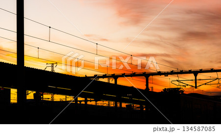 夕暮れ時の駅のホームとオレンジ色に染まった空 134587085