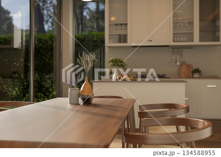 Set of wooden table and armchairs with decorative dried flower vase in modern kitchen or dining room 134588955