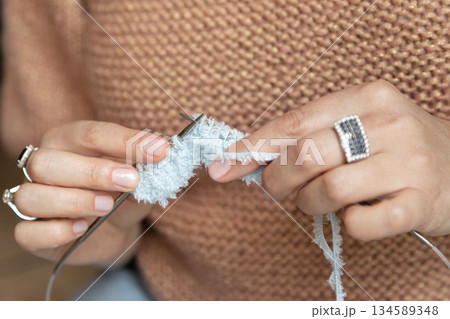 Hands Knitting Soft White Yarn Close-Up. A woman knit with knitting needles,closeup shot Hands Knitting Soft White Yarn Close-Up. A woman knit with knitting needles,closeup shot 134589348