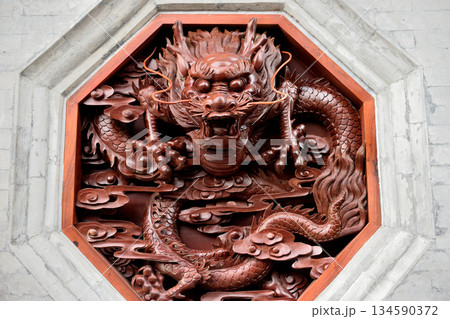 Intricate wooden dragon carving in octagonal frame Intricate wooden dragon carving in octagonal frame 134590372