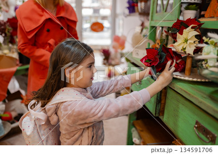 Little girl explores colorful flowers while shopping in a charming local store during autumn 134591706