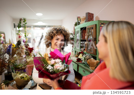 Smiles exchanged over a vibrant bouquet in a charming flower shop on a sunny afternoon Smiles exchanged over a vibrant bouquet in a charming flower shop on a sunny afternoon 134591723