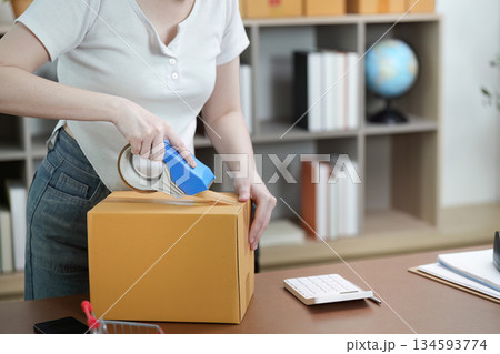 Small Business. Entrepreneur sealing packages for shipping. Small Business. Entrepreneur sealing packages for shipping. 134593774