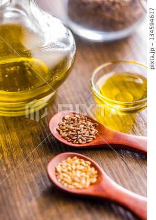Brown and gold linseed or flaxseed . Healthy flax seed on wooden spoon on wooden table. Brown and gold linseed or flaxseed . Healthy flax seed on wooden spoon on wooden table. 134594617