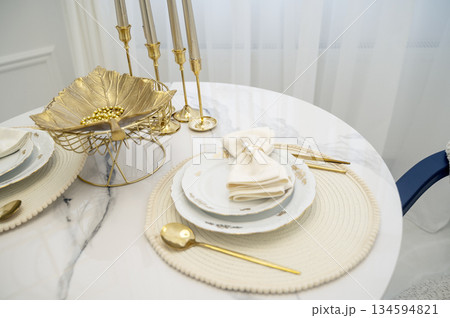 Elegant dining setup with neatly arranged plates and bowls on a light background 134594821