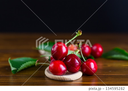 Bright cherries in a minimalist composition on a wooden table Bright cherries in a minimalist composition on a wooden table 134595282