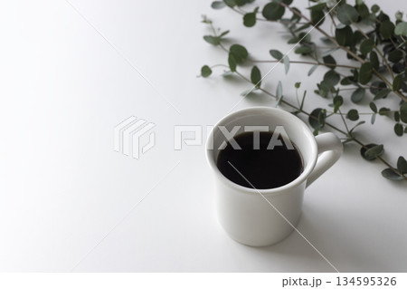 余白のある白いマグカップのブラックコーヒーとユーカリ 134595326