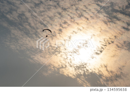 Flying on a paraglider with a propeller, an extreme kind of leisure. Parachuting, a man flying in the sky 134595638