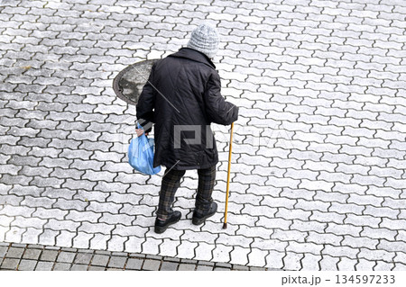 日本の横浜都市景観 見えにくい段差や凹凸…高齢化社会…杖の高齢女性…冬至で冷え込む 134597233