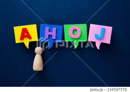 Wooden figure communicating greeting ahoj in speech bubbles 134597778