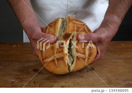Breaking of a fresh loaf of Eucharistic bread Breaking of a fresh loaf of Eucharistic bread 134598095