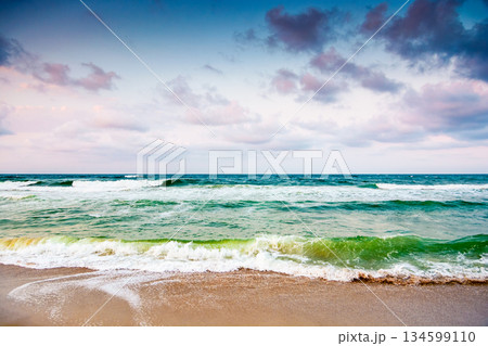black sea waves crashing sandy beach of bulgaria. summer vacation on a windy weather day under dark cloudy sky. view of dramatic seascape. background for desperate tourism in bad weather concept 134599110