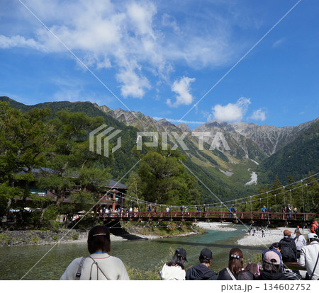 秋の観光名所上高地の観光スポット河童橋で梓川と穂高連峰の風景を楽しむ大勢の観光客の姿 134602752