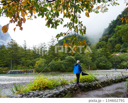 雨の日の観光名所上高地の梓川の風景と沿岸で散策する観光客の姿 雨の日の観光名所上高地の梓川の風景と沿岸で散策する観光客の姿 134602791