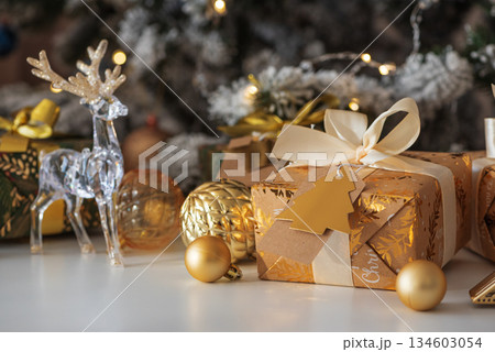 Crystal Reindeer with Gold Antlers and Christmas Gifts in Festive Interior 134603054