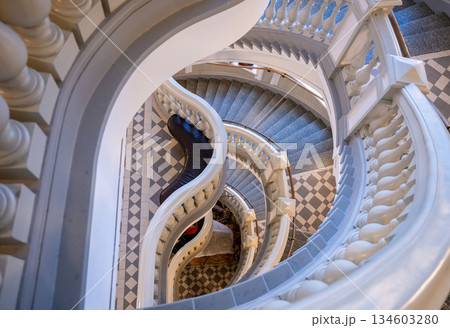 Elegant spiral staircase with classic balustrade and tiled floor 134603280