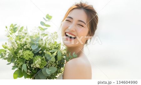 ナチュラルな花束を抱えて微笑む若い女性のポートレート ナチュラルな花束を抱えて微笑む若い女性のポートレート 134604990