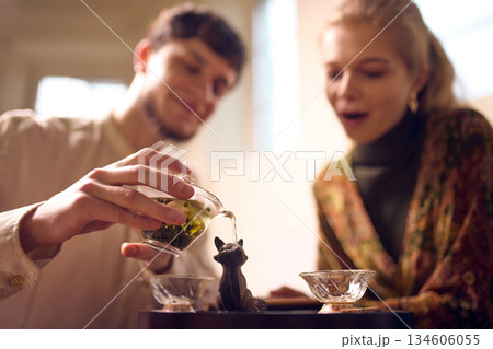 Close-up of tea infusion poured between cups during ceremony. 134606055