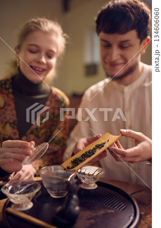 Couple examining loose tea leaves during traditional tea ceremony. Couple examining loose tea leaves during traditional tea ceremony. 134606060