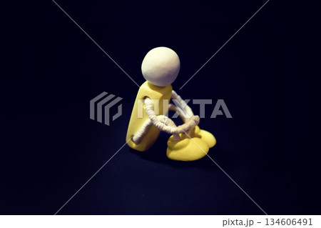 膝を抱えている木製人形の写真 孤独 落ち込む 後悔 寂しい ネガティブな感情のイメージ 膝を抱えている木製人形の写真 孤独 落ち込む 後悔 寂しい ネガティブな感情のイメージ 134606491