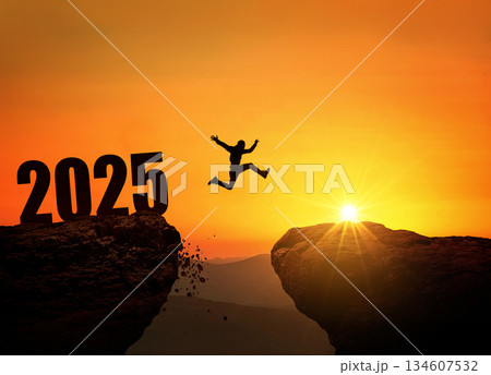 Silhouette of a person jumping across a cliff with the number 2025 at sunset. Concept of new year, challenge, success, goals, future opportunities, and overcoming obstacles. 134607532