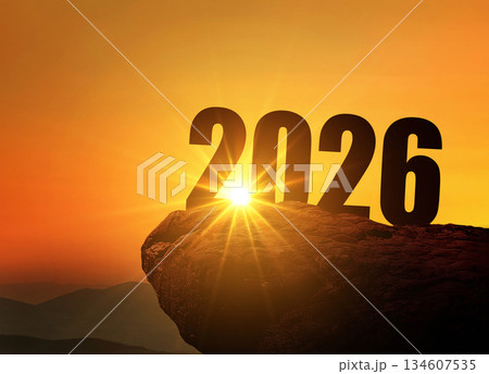 New Year 2026 at sunset. Silhouette 2026 stands on a mountain with sun rays at sunrise, creative idea. Year 2026, concept New Year 2026 at sunset. Silhouette 2026 stands on a mountain with sun rays at sunrise, creative idea. Year 2026, concept 134607535