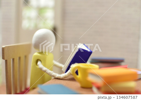 読書をする木製人形の写真　積まれた本　趣味の時間　勉強 134607587