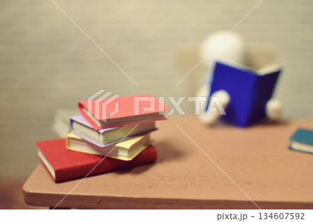 読書をする木製人形の写真　積まれた本　趣味の時間　勉強　ミニチュア 134607592