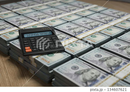 Stacks of hundred-dollar bills with a calculator on top. Finance, investment, banking, savings, and wealth management. Perfect for illustrating money, accounting, or business success concepts 134607621