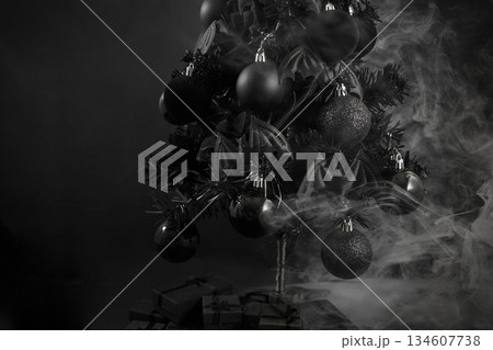 Gothic Christmas. A black Christmas tree adorned with dark ornaments and surrounded by mist 134607738