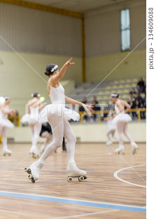 Girls roller skating artistic performance in white uniform Girls roller skating artistic performance in white uniform 134609088