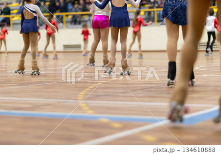 Girls roller skating on wooden sport court during performance 134610888