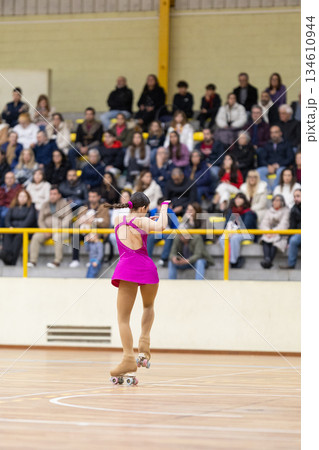 Female roller skater performing artistic routine for audience 134610944