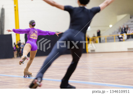 Pair artistic roller skaters performing dynamic routine 134610951