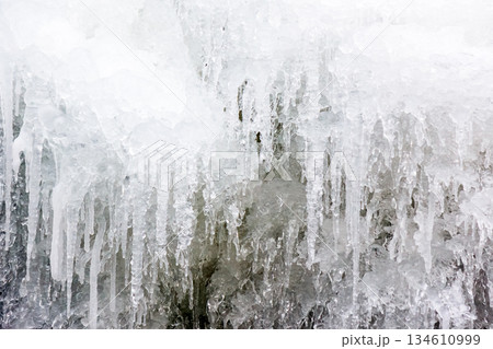 frozen waterfall close up view. icicles hanging above water. cold winter landscape photography on river tyrychka of transcarpathia ukraine. seasonal nature texture. background for climate change 134610999
