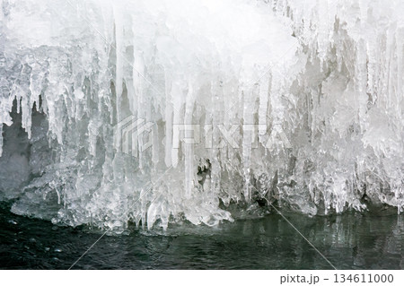 frozen waterfall close up view. icicles hanging above water. cold winter landscape photography on river tyrychka of transcarpathia ukraine. seasonal nature texture. background for climate change frozen waterfall close up view. icicles hanging above water. cold winter landscape photography on river tyrychka of transcarpathia ukraine. seasonal nature texture. background for climate change 134611000