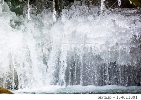 frozen waterfall close up view. icicles hanging above water. cold winter landscape photography on river tyrychka of transcarpathia ukraine. seasonal nature texture. background for climate change frozen waterfall close up view. icicles hanging above water. cold winter landscape photography on river tyrychka of transcarpathia ukraine. seasonal nature texture. background for climate change 134611001