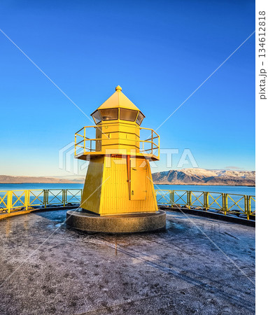Yellow Lighthouse by the Sea with Mountains in Iceland 134612818