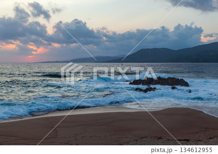 Dramatic view of shoreline with rocky formations and gently lapping waves. Corsica 134612955