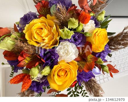 Colorful flower bouquet arranged on a light surface indoors. Floral composition, celebration mood, gift idea and decorative arrangement 134612970