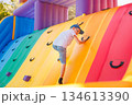 Child Climbing Colorful Inflatable Wall at Outdoor Playground 134613390