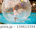 Child Enjoying Water Walking Ball Adventure in Pool 134613394